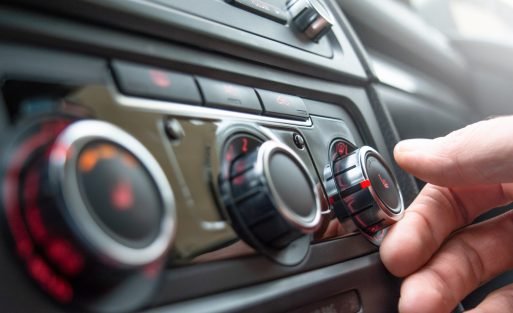 Button for heating the car seats close-up. The male hand presses the button for heating the seats of the car.